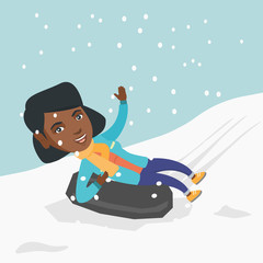 Sticker - Young joyful african-american woman sledding on snow rubber tube and waving hand. Woman sitting on a snow rubber tube. Winter leisure activity concept. Vector cartoon illustration. Square layout.