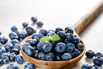 Wall Mural - Wooden spoon with blueberries. Fresh berries isolated on white background