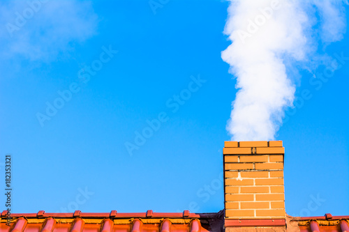 Cuadros en Lienzo Modern house roof with chimney smoke, air pollution and smog in winter, ecologic