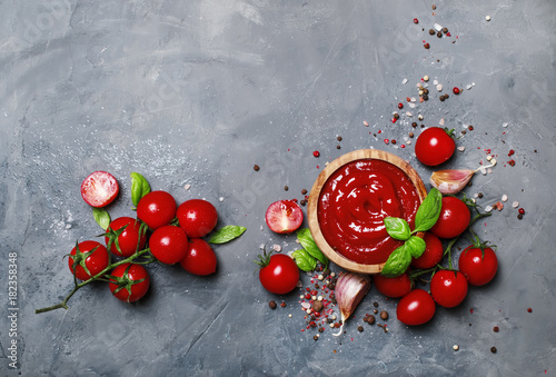 Fotografía Tomato ketchup sauce with garlic, spices and herbs with cherry tomatoes in a woo