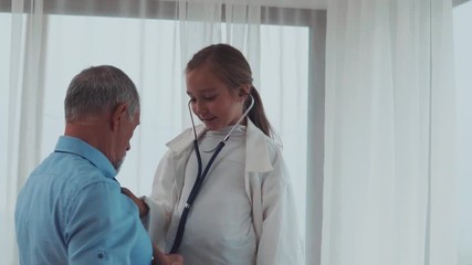 Wall Mural - Senior doctor and a small girl in his office.