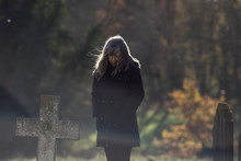 Mortality. Living With Grief. Lady Mourns At Old Cemetery Grave On A Cold Autumnal Morning.