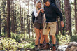 © Jacob Lund - Hiking couple walking on rocks in forest wearing backpacks