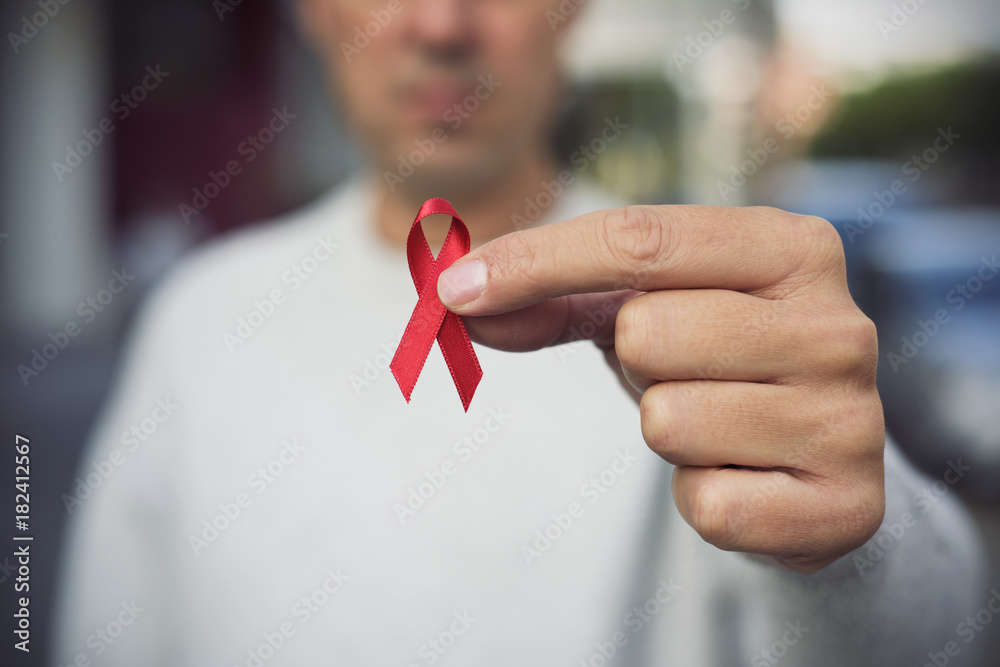 man with red ribbon for the fight against AIDS - obrazy, fototapety, plakaty 