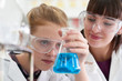 © highwaystarz - Female Pupil And Teacher Conducting Chemistry Experiment