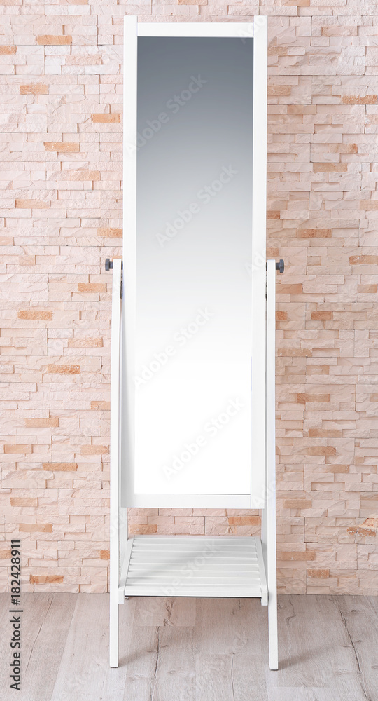 Modern big mirror near brick wall