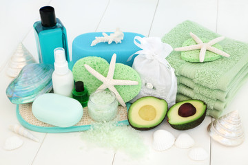 Wall Mural - Skincare and body care spa beauty treatment with avocado, bath salts, sponges, face cloths, tea tree aromatherapy essential oil, body lotion, bath foam, soap and decorative shells on white wood.