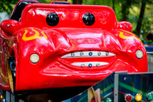 Small Red Car With Face In Amusement Park
