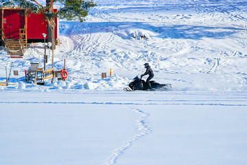 Poster - Man riding snowmobile on lake at winter Rovaniemi