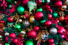 Red And Green Holiday Ornaments On A Christmas Tree