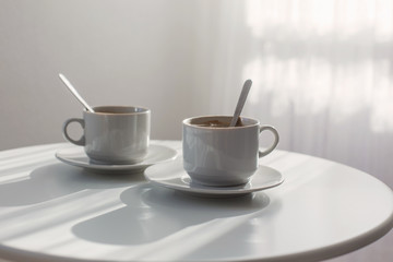 two white cups on white table