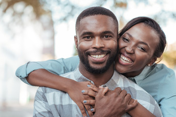 Affectionate young African couple standing outside on a sunny day