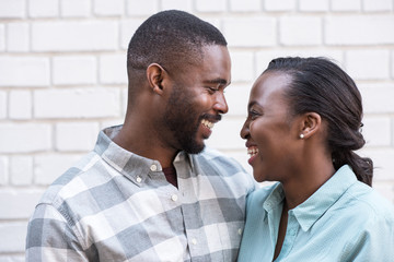 Wall Mural - Content African couple smiling at each other in the city