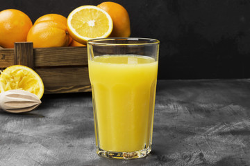 Oranges and fresh orange juice on a black background