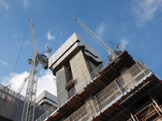 Wall Mural - cranes and construction machinary working on a large development site with concrete service core