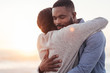 © mavoimages - Happy young African couple embracing each other at the beach