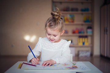 cute little girl draws with crayons