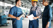 © NDABCREATIVITY - Factory worker discussing data with supervisor in metal factory