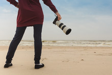 Woman Walking On Beach With Camera