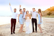 © Africa Studio - Happy wedding couple having fun with friends on beach