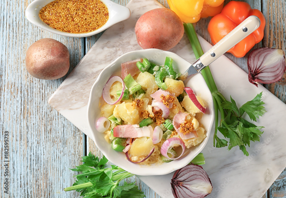 Composition with delicious potato salad and mustard sauce on table
