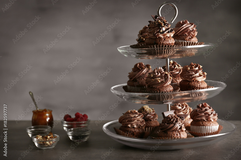 Dessert stand with tasty chocolate cupcakes on table