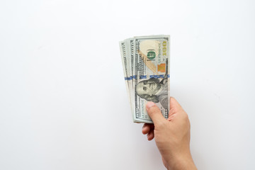 Human hand holding money of one hundred dollar bills isolated on white background.