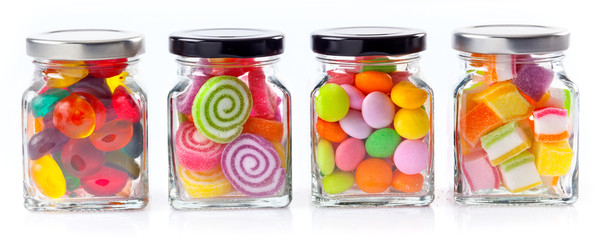 colorful candies in glass jars on white background - Web banner with food concept