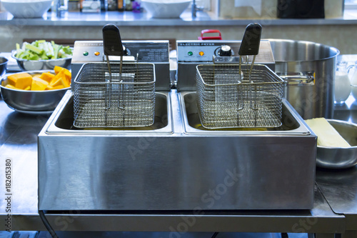 Fotomural Professional fryer - machine for deep cooking in fat - in kitchen interior on metal table