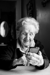 Wall Mural - An elderly woman holding a smartphone.