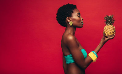 Black woman looking at pineapple