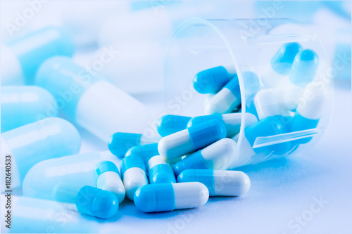 Fotografia capsules of medicine spilling out of the medicine cup