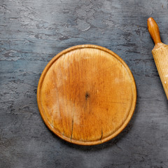 Aufkleber - Wooden board with rolling pin on the dark stone surface