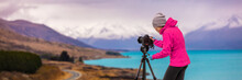 Woman Photographer Taking Picture Of Travel Landscape Panoramic Banner. New Zealand Nature Photography With Slr Camera On Tripod At Sunset With Autumn Background At Peter's Lookout