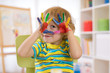 © Oksana Kuzmina - cute cheerful kid boy showing hands painted in bright colors