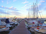 Fototapeta Pomosty - Luxury yachts and sailboats in seaport at sunset. Marine parking of modern motor boats in Liguria, Italia