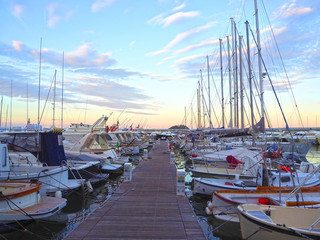 Wall Mural - Luxury yachts and sailboats in seaport at sunset. Marine parking of modern motor boats in Liguria, Italia