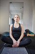 Junge Frau im Schneidersitz macht Yoga Übung
