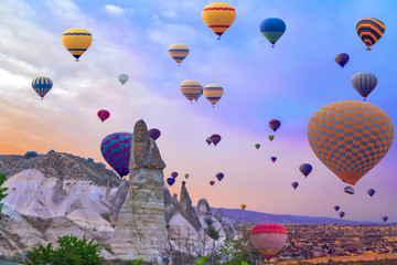 Wall Mural - sunset Hot air balloons landing in a mountain Cappadocia Goreme National Park Turkey.