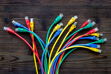 Network wires assorted colors with tips on dark wooden background top view