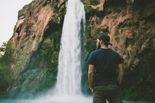 Man In Front Of Beautiful Blue Waterfall
