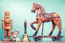 Retro Antique Christmas Wooden Horse On Wheels, Old Nutcracker Toy, Angel And Bronze Jingle Bell. Holiday Greeting Card Concept. Vintage Instagram Style Filtered Photo