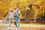 Fototapeta  - Young couple walking in park on autumn day