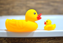 Concept Of Muther And Baby. Children's Rubber Ducky In The Bathtub For Baby Bathing.