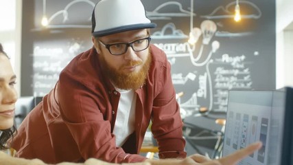Poster - Beautiful Woman Developer Uses Personal Computer and Talks With a Bearded Programer in a Cap, Together They Design New Mobile Video Game/ Application. Shot on RED EPIC-W 8K Helium Cinema Camera.
