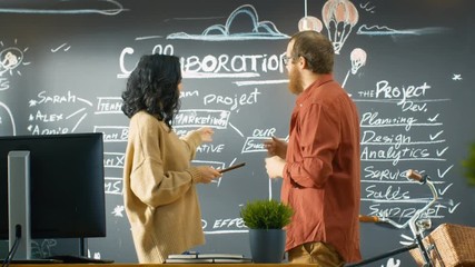 Poster - Female Project Manager Holds Tablet Computer Talks with Male Developer, They Discuss Project Plan Drawn on a Blackboard Wall. They Work in the Creative Agency. 4K UHD.