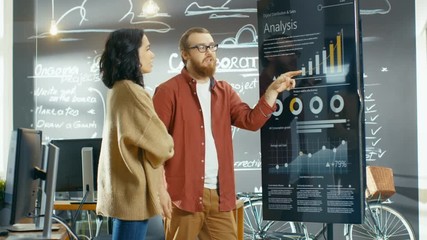 Poster - Female Developer and Male Statistician Use Interactive Whiteboard Presentation Touchcreen to Look at Charts, Graphs and Growth Statistics.  Shot on RED EPIC-W 8K Helium Cinema Camera.