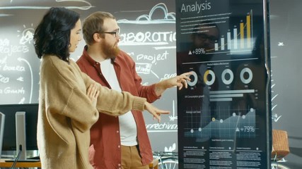 Poster - Female Developer and Male Manager Use Interactive Whiteboard Presentation Touchcreen to Look at Charts, Graphs and Growth Statistics. Shot on RED EPIC-W 8K Helium Cinema Camera.
