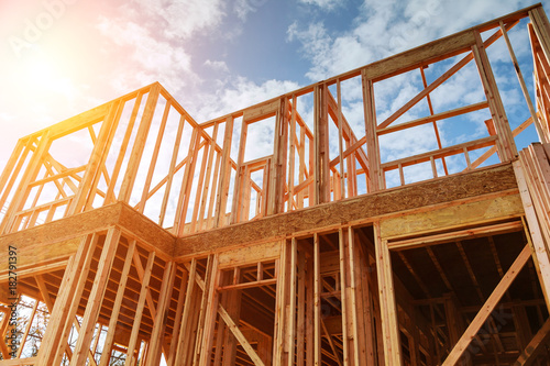 Fotografia, Obraz New residential construction home framing against a blue sky.