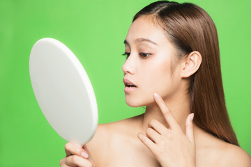 Young woman checking her skin. Skin care concept.